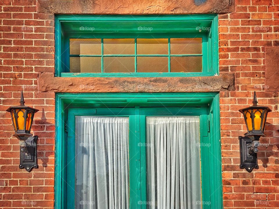 Old fashioned wall lanterns beside a green door