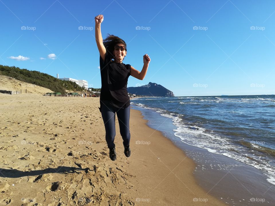 woman enjoys jumping on the beach