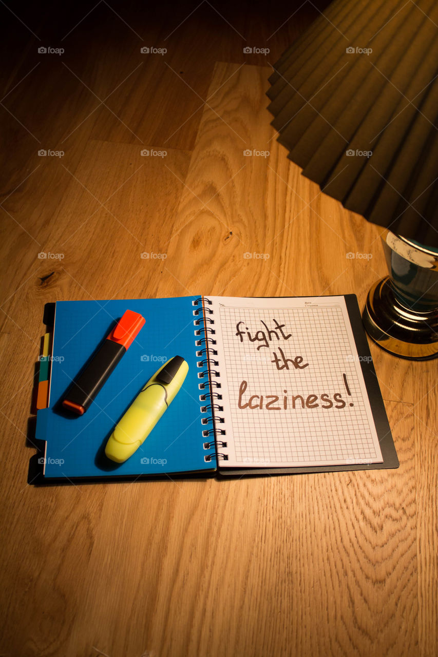 Motivational letter in a notebook on the desktop under the light of a lamp