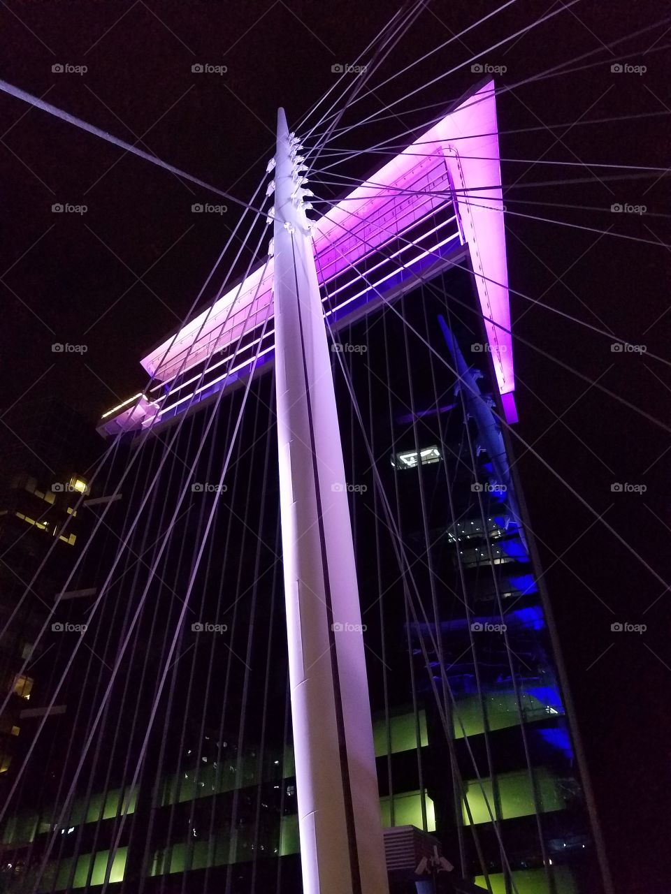 The beautiful suspension bridge in downtown Denver,  CO at night.  Lit by LED's, it can be seen from all other the city. This is a must see landmark in Denver.