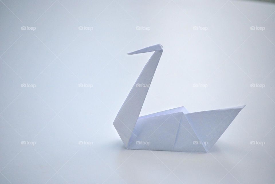 White paper origami swan on white background