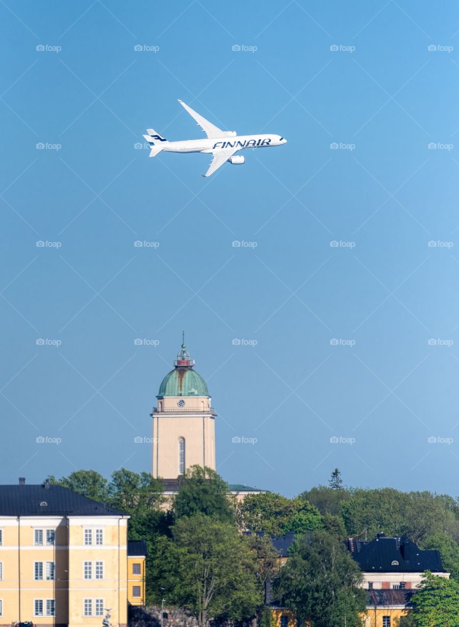Helsinki, Finland - 9 June 2017: Finnair Airbus A350 XWB airliner flying in extremely low altitude over Suomenlinna fortress island at the Kaivopuisto Air Show.