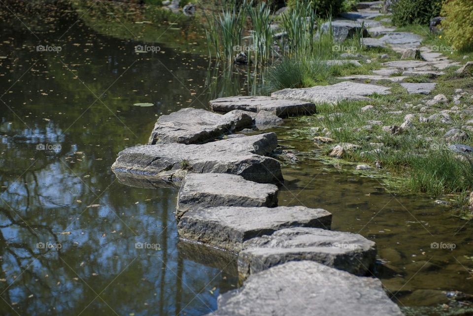 Path of stones through the pond.  Leisure and travel.