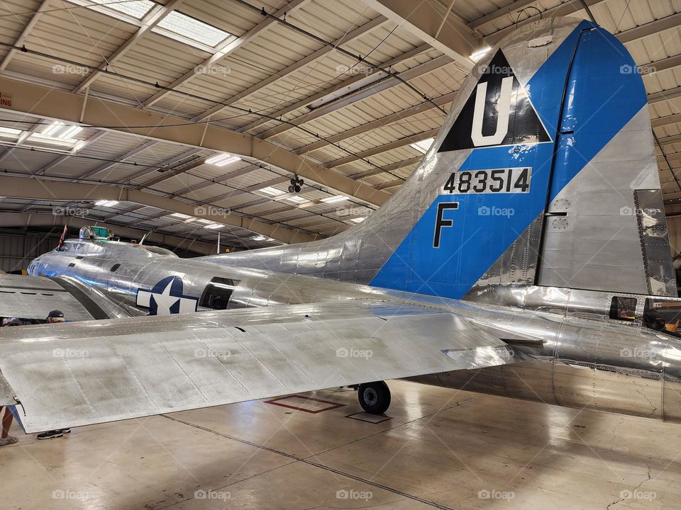 A perfectly restored Boeing B-17G bomber produced in 1945 sits in a hangar as people are allowed to walk through it