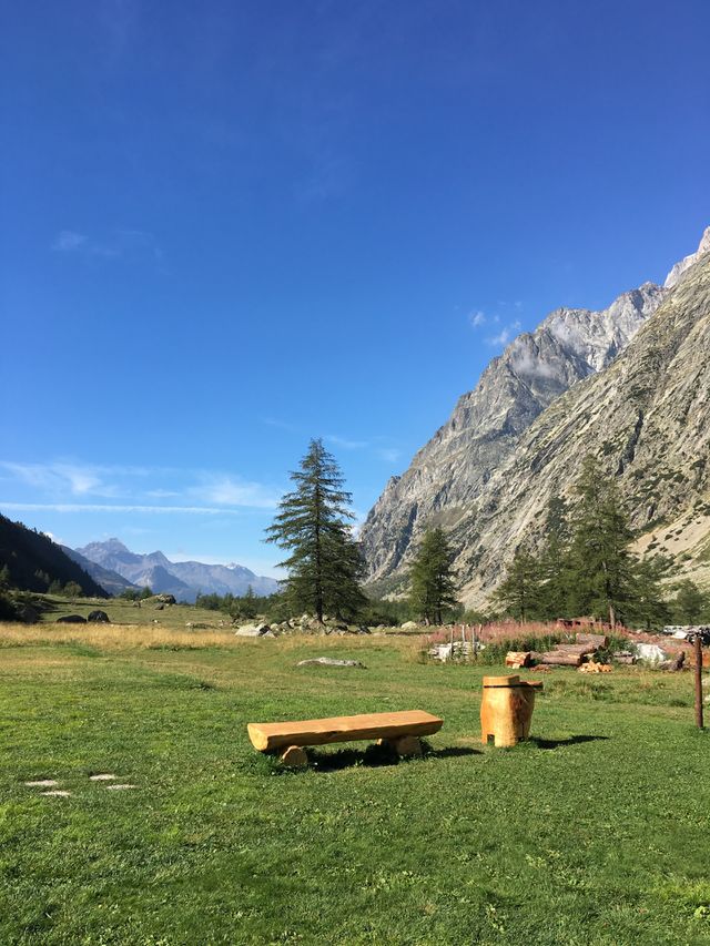 A sunny day, a simple wood bench as an invitation to enjoy mountainous beauty