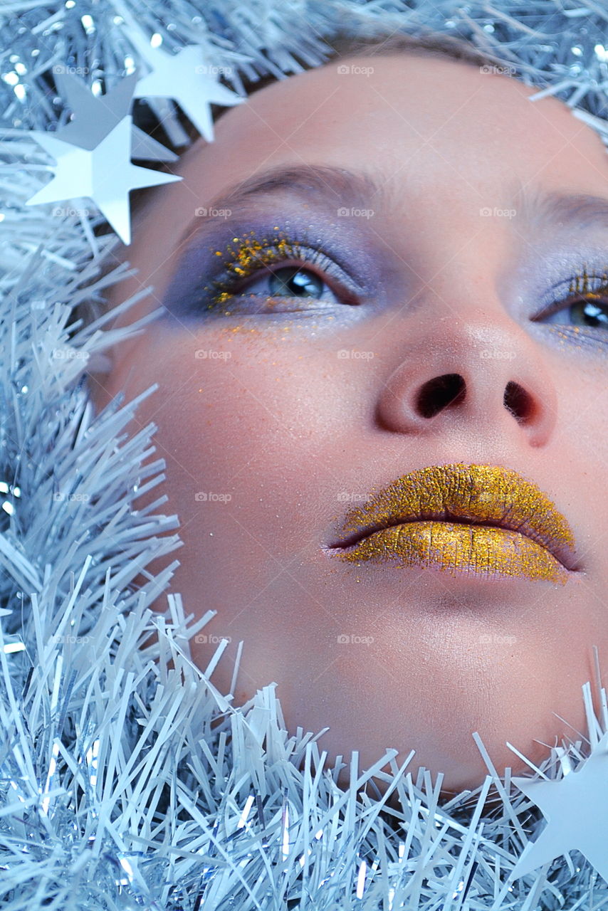 Fashionable woman makeup with tinsel garland