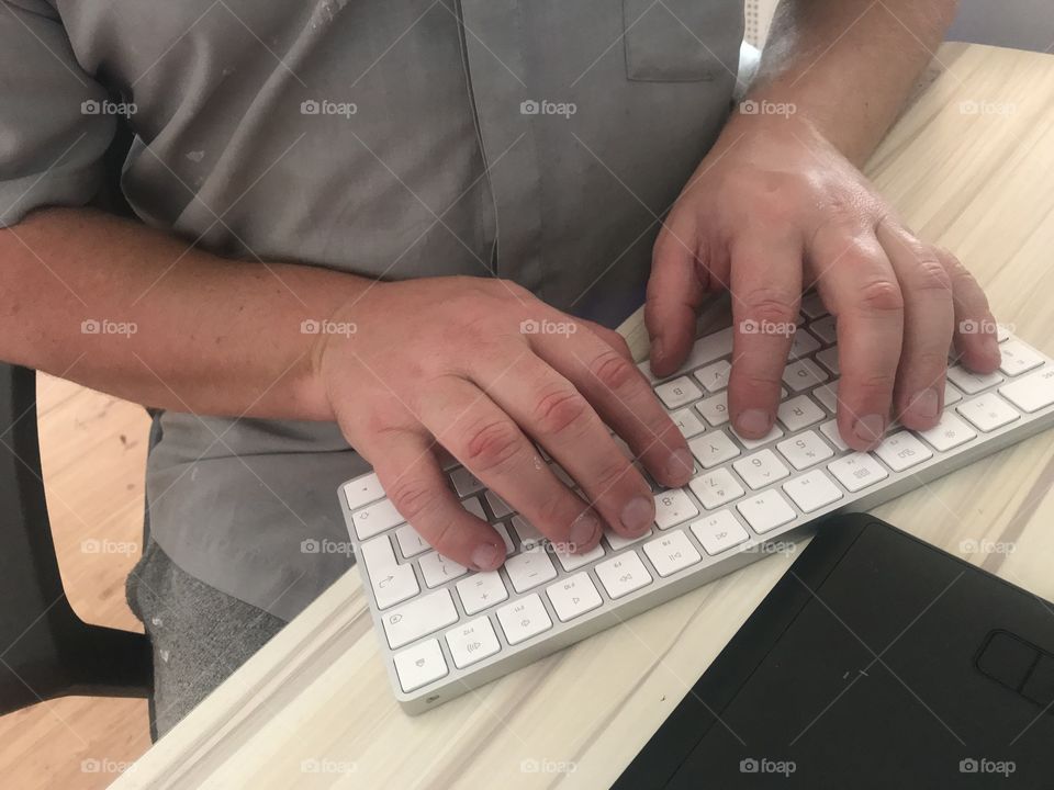 Hands at work on wireless keyboard in home office
