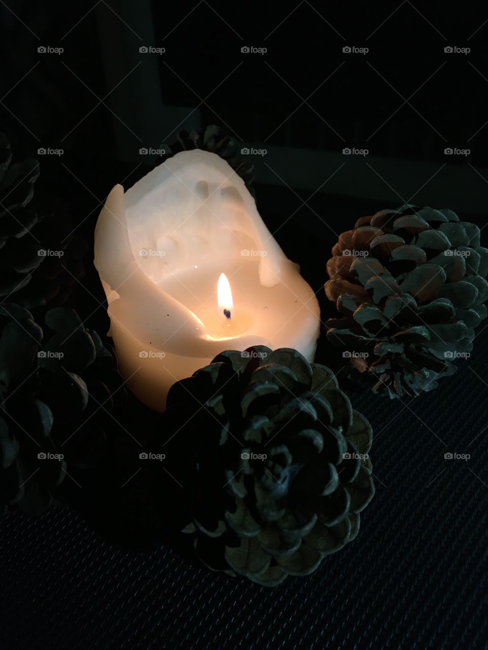Candle light with pine cones 