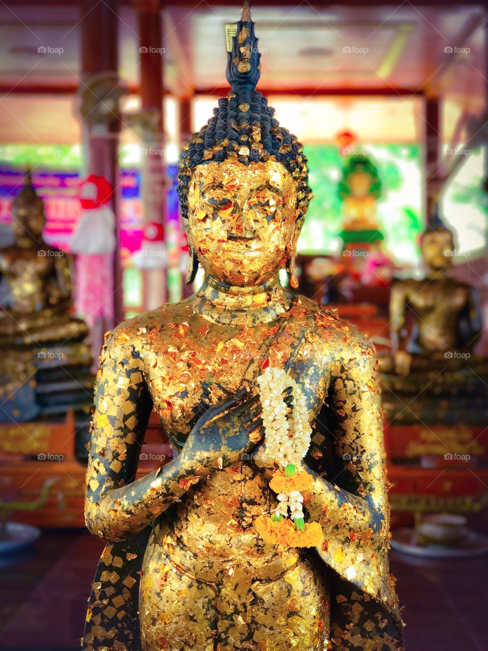 Buddha image covered by gold leaf in temple