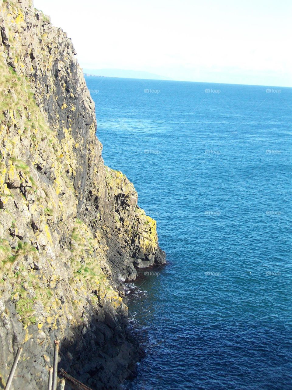 looking down the cliff into the sea at Carrick-a-rede