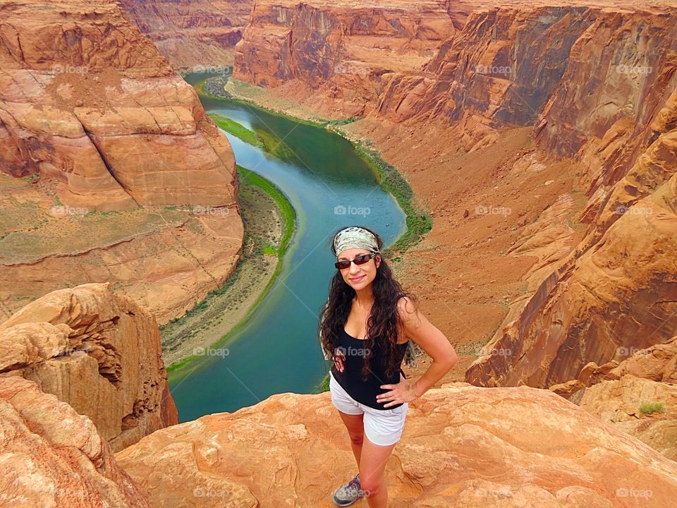 Stylish woman posing on top of the rocky mountain