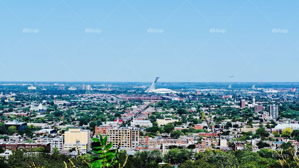 A view of the City of Montreal from atop Mt Royal at the Camillien-Houde lookout- the iconic Olympic Stadium quite visible on the horizon and the Jacques Cartier Bridge