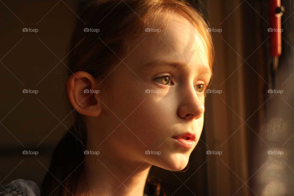 The girl looks at the sunset, reflected in her eyes, through the train window and talks about her impressions