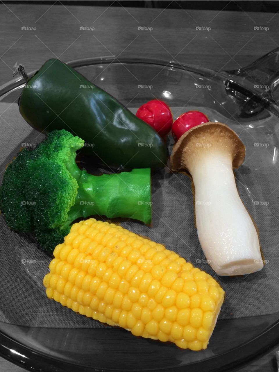 Plastic vegetables on a grass pan. 