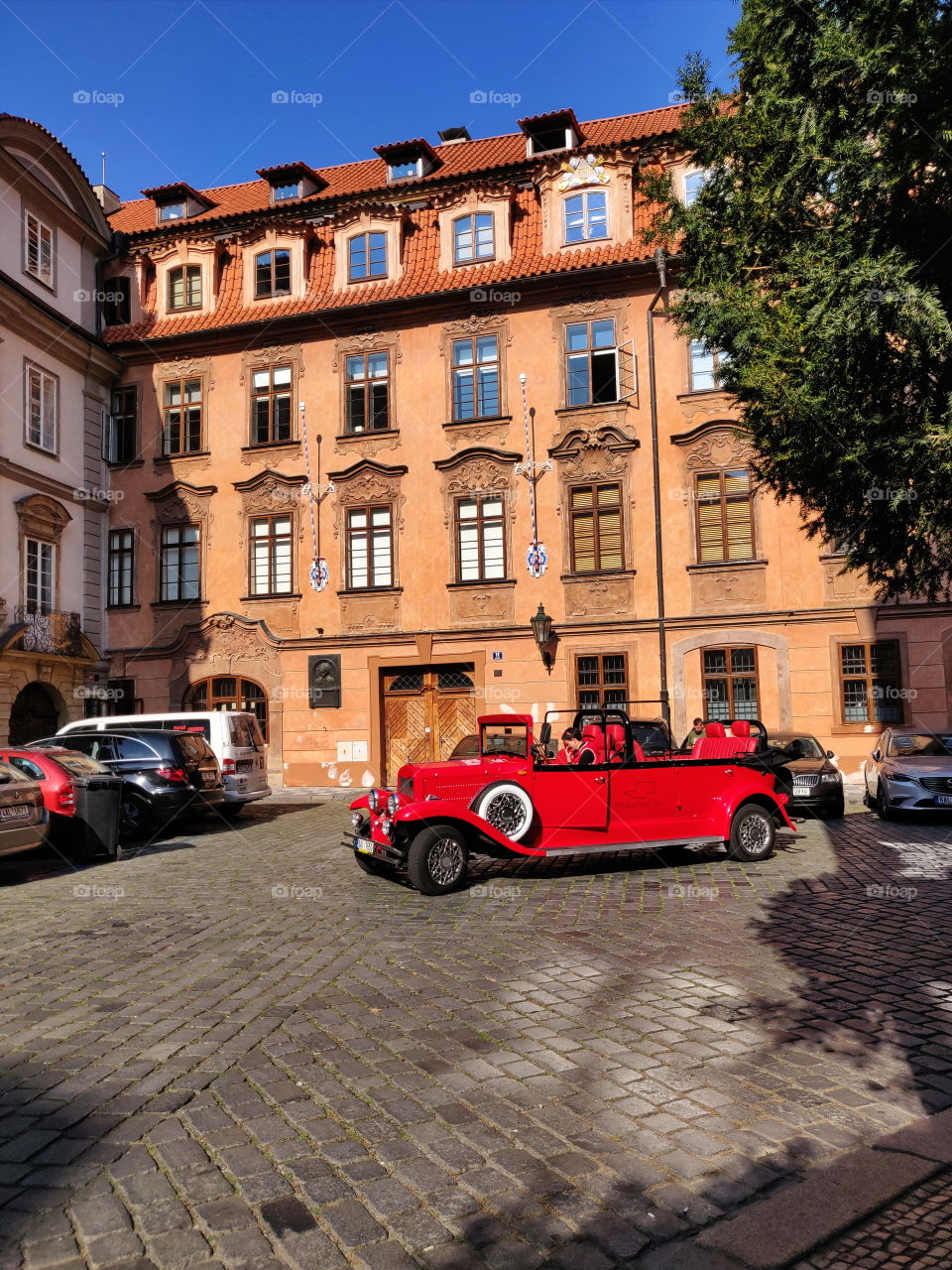 red limousine in the courtyard of the old city of prague