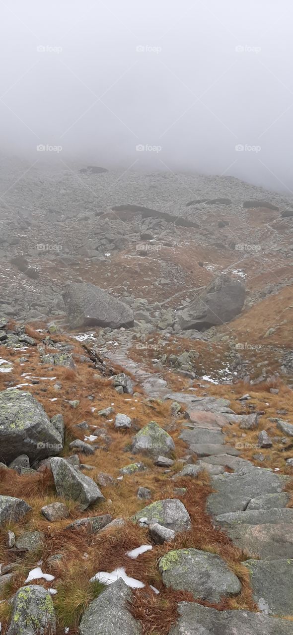 Trail in rocky and misty mountains