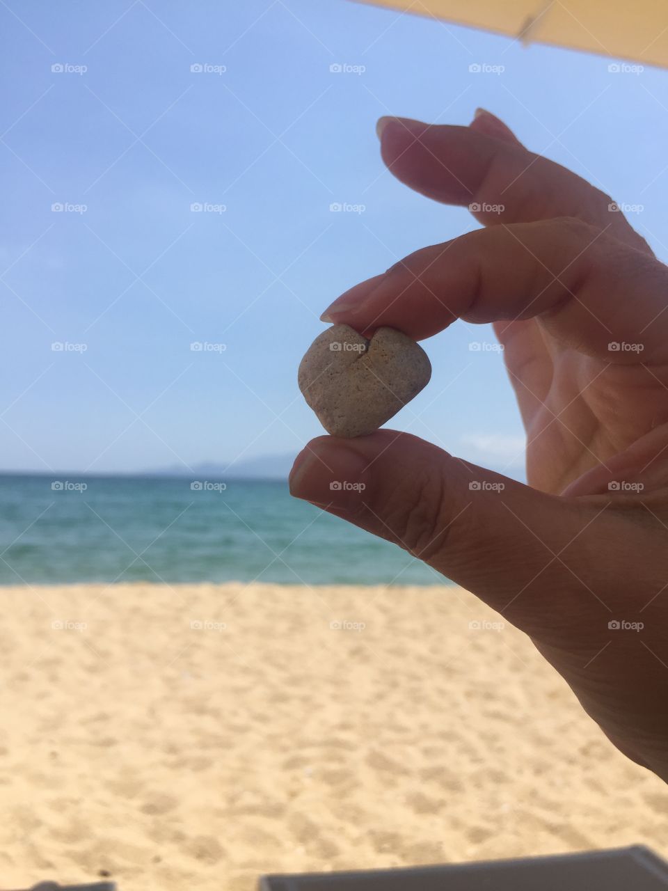 hand holding stone with shape of heart