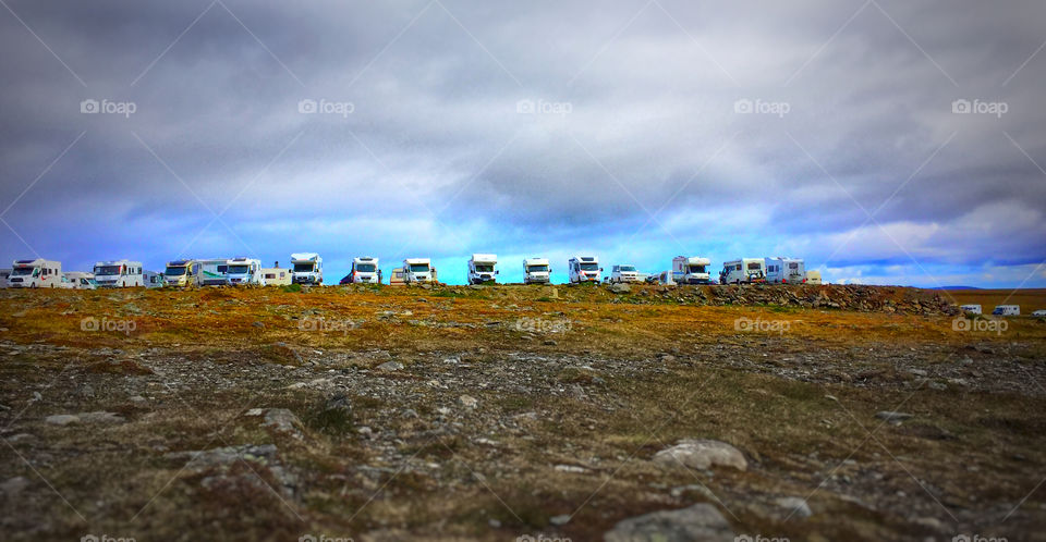 Camper vehicles lined up in a field in Nordkapp (North Cape) Norway, the northernmost point in Europe accessible by car