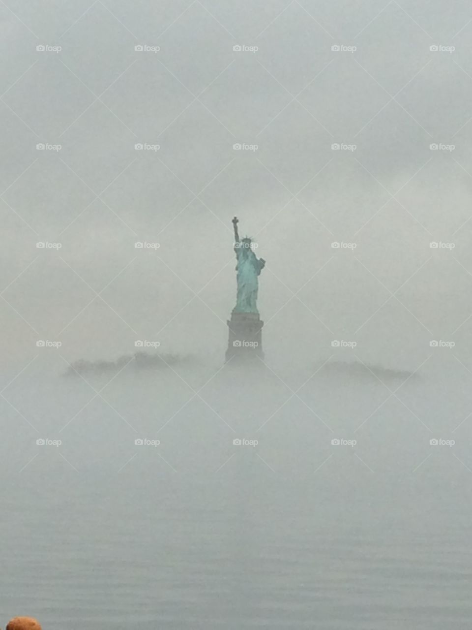 Lady Liberty . Statue of Liberty through the fog in New York City from the Staten Island Ferry