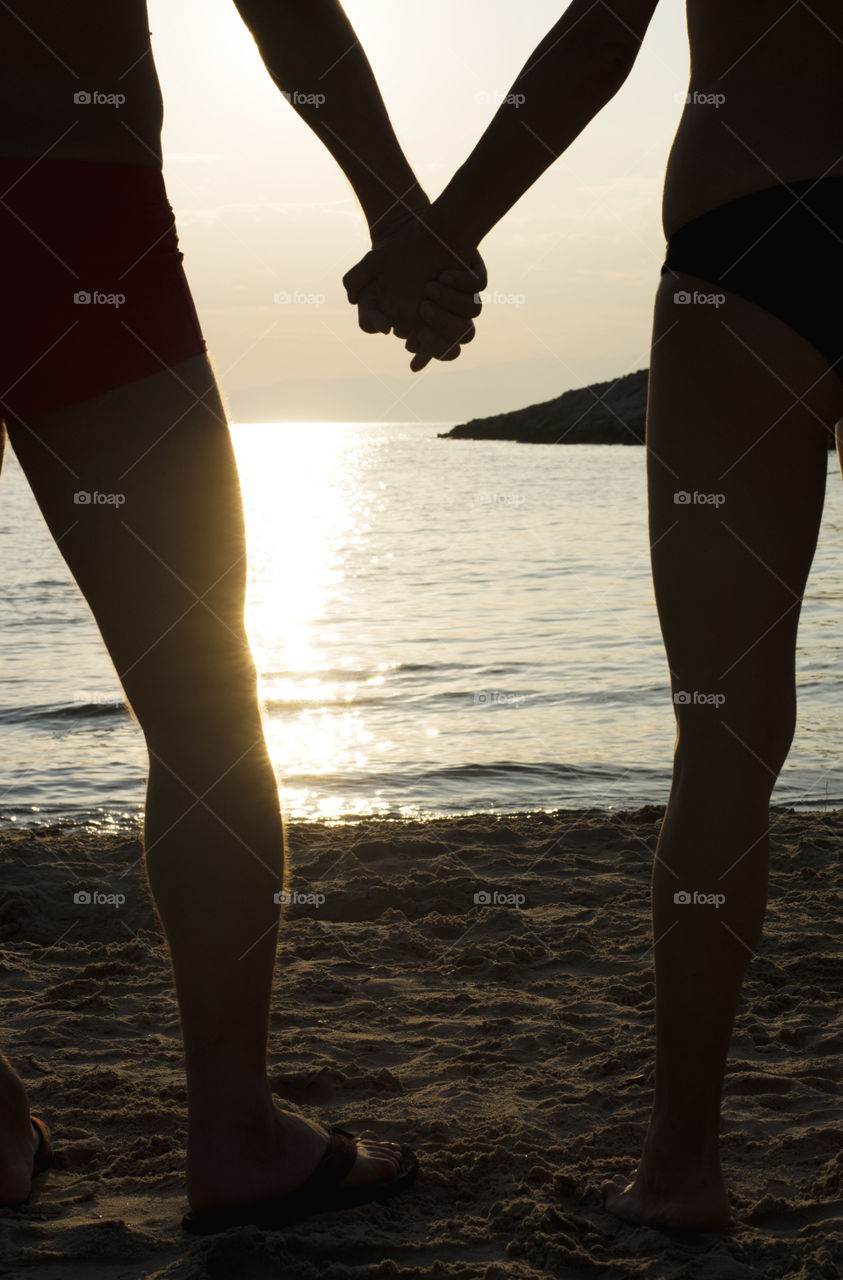 couple holding hands. couple in love holding hands at beach at sunset,silhouette effect