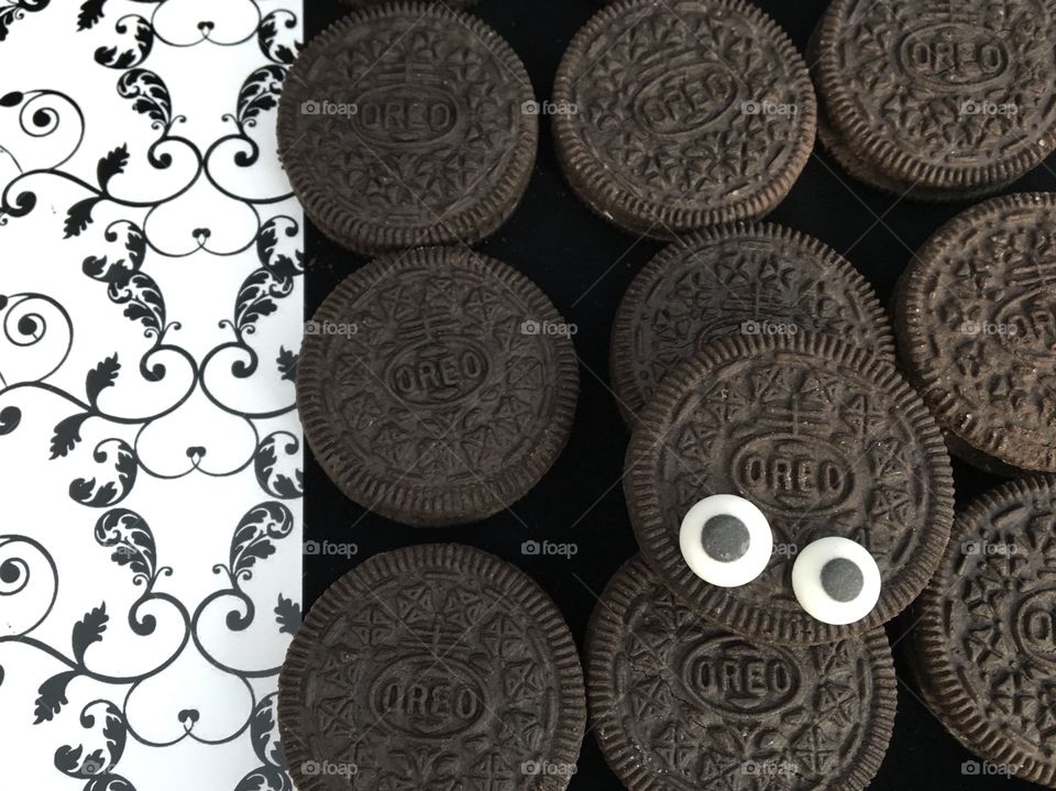 Oreo Biscuits Flatlay .. black and white goggly monster eyes peeping out from the top of an Oreo