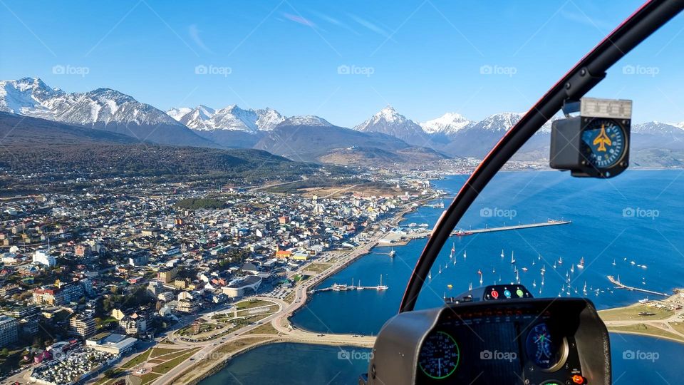 aerial view from a helicopter, below us the Beagle Channel, the city of Ushuaia and the mountains that surround it.