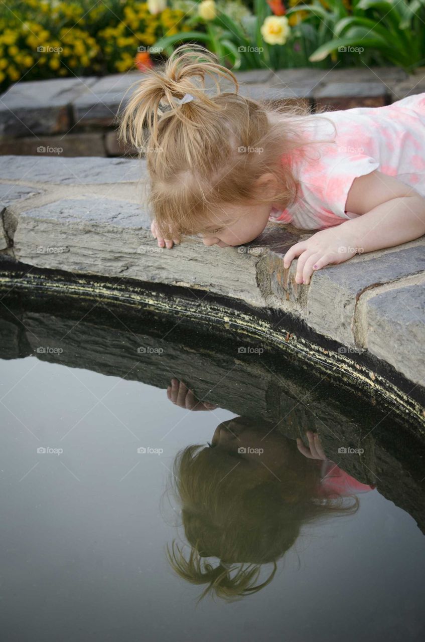 Blonde girl looking at pond