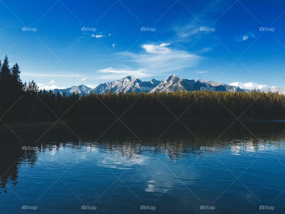 Rockie Mountains full of cliffs with a beautiful mountain lake in the foreground. 