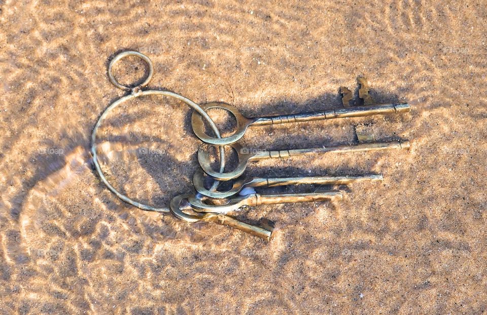 Ring Of Old Brass Keys In Clear Shallow Water