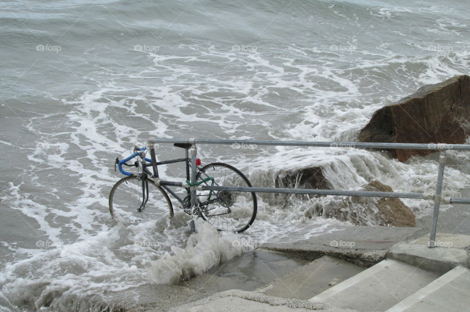 A Beached Bike. A carelessly left bicycle being swept up by the waves near Wells Beach in Maine.