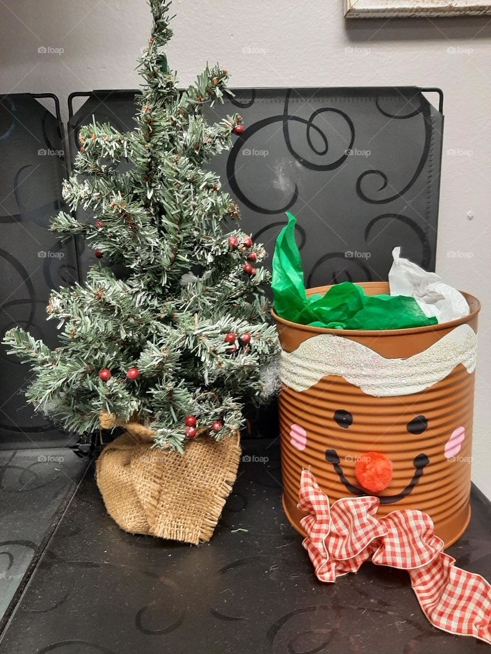 little Christmas tree with a tin with happy face.