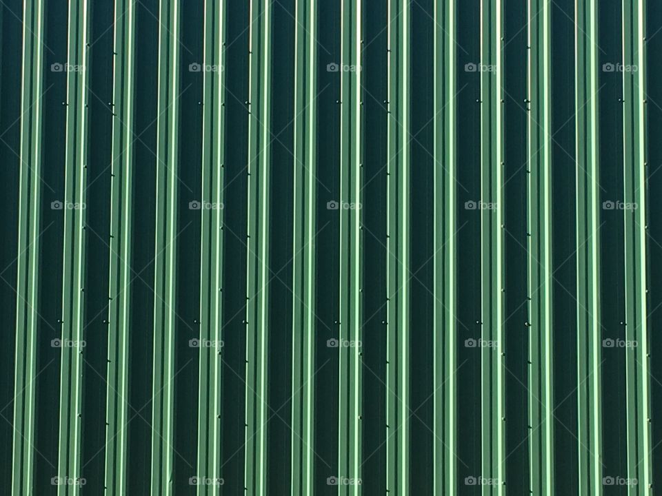 Texture of a shed wall, shade and shadow of green and black on a large surface area. 