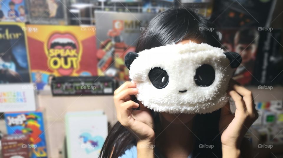 A girl holding a panda eyemask