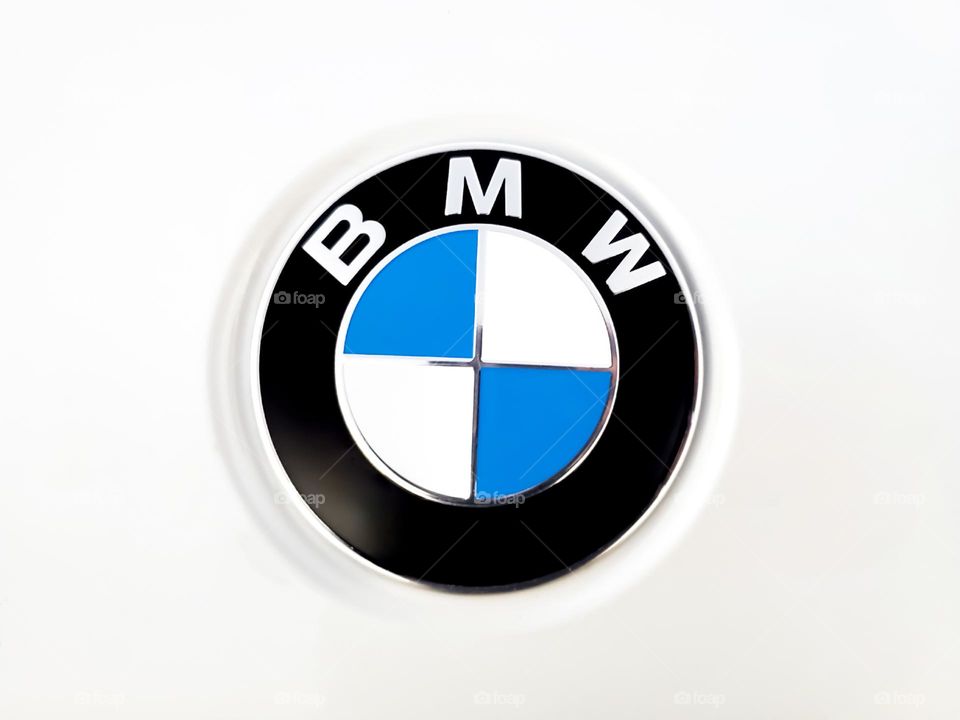 Circles: BMW logo emblem on white car.