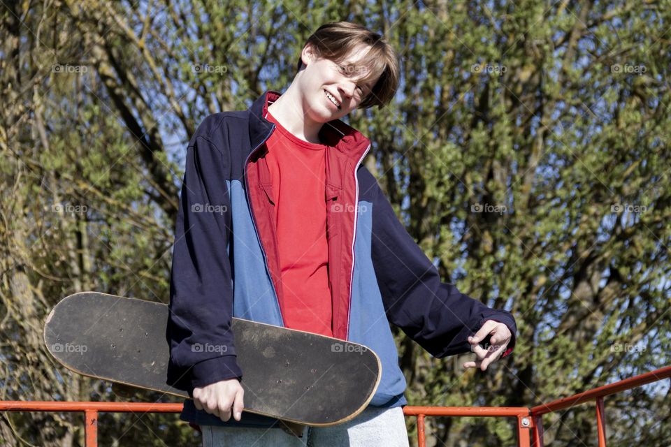 Hobbyist teenager goes in for sports, has fun and rides a skateboard in the park outdoors.