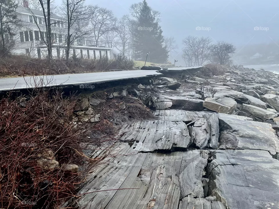 High waves and storm surge has eroded beneath a coastal road.