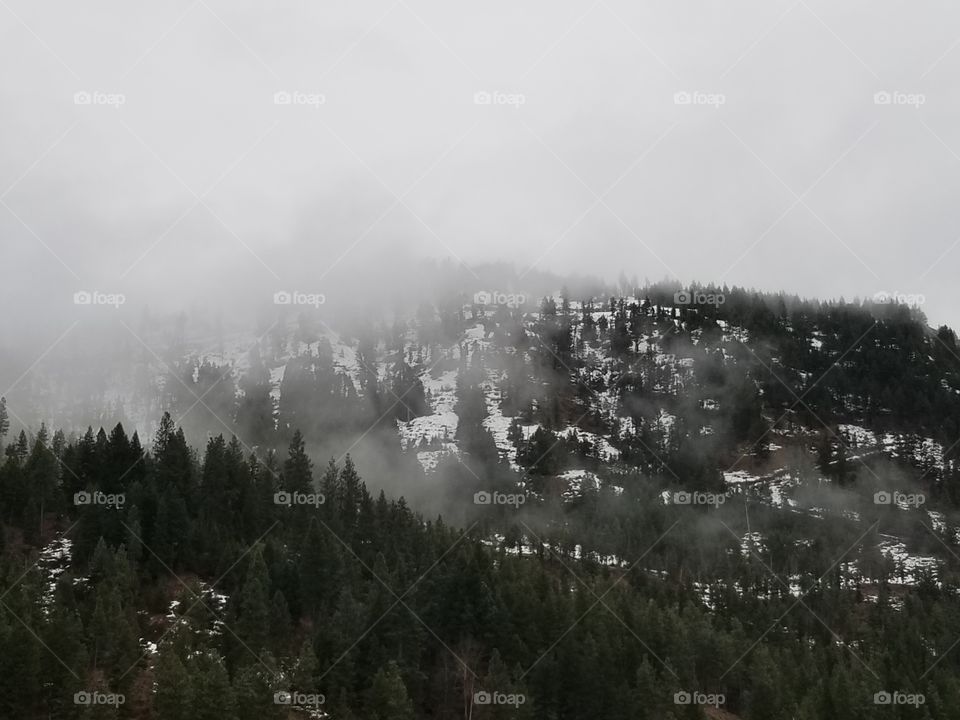 Low hanging clouds, late spring snow up i in the higher elevations