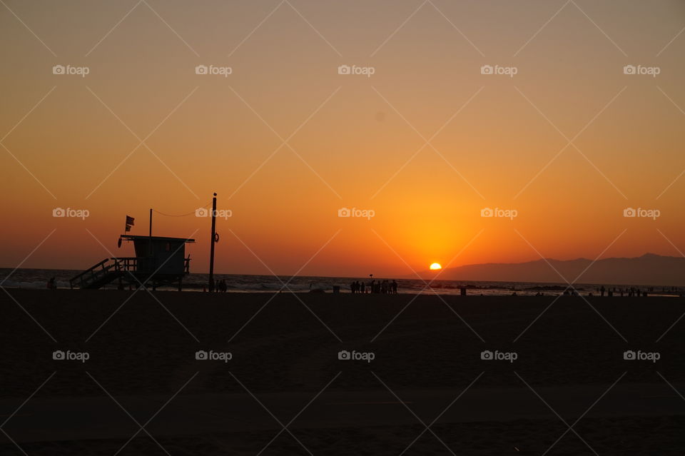 Silhouette of a lifeguard hut on Venice beach at sunset