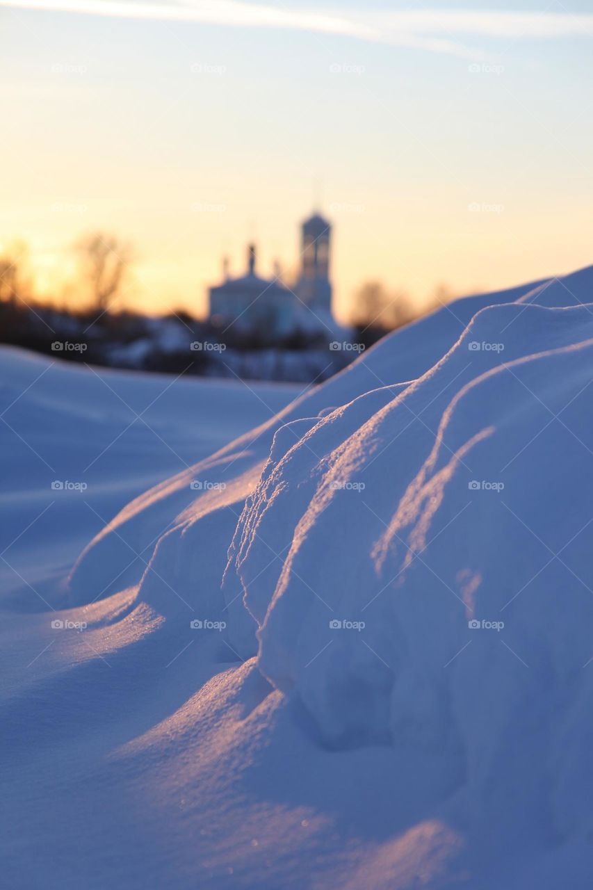 winter evening with setting sun and reflections on the snow