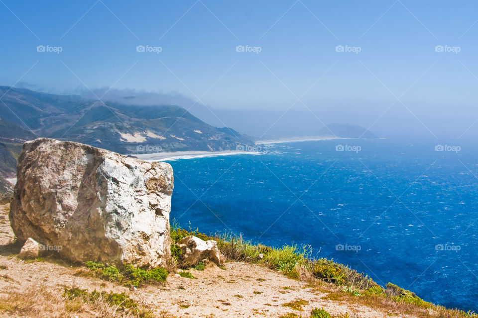 Scenic view of cliff and sea against sky