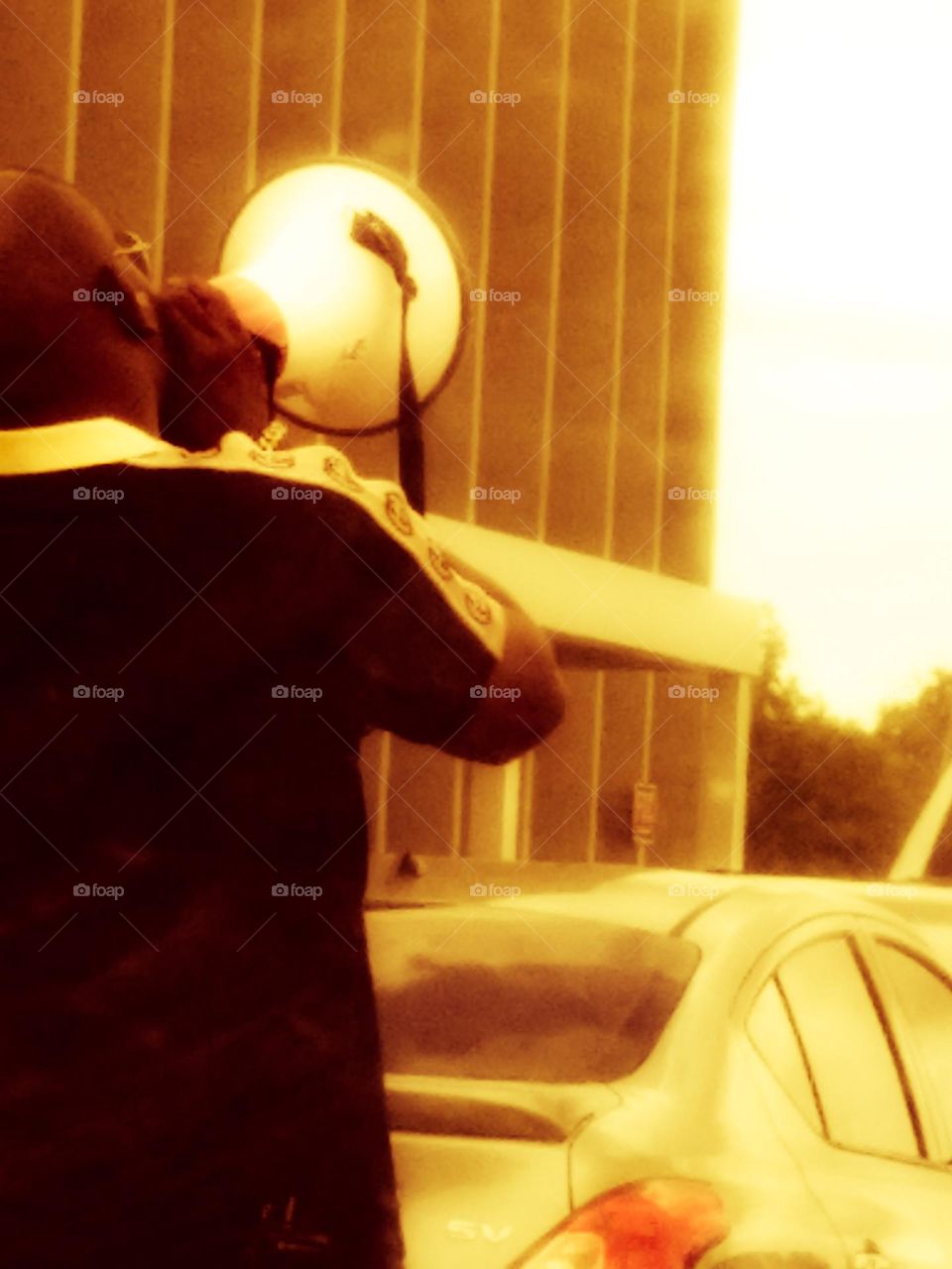 A school employee on a megaphone 📣 talking to some students outside after school 🎒.