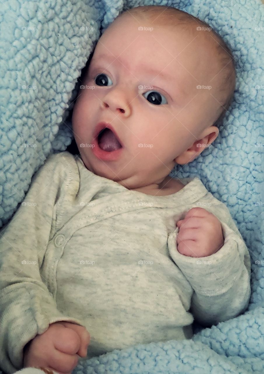 An adorable baby boy with a surprised expression on his face.