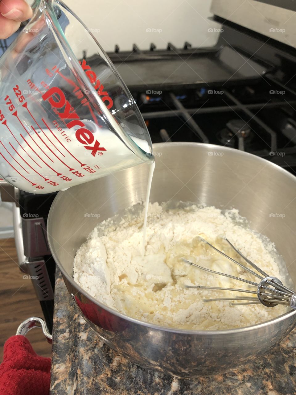 Milk poured into bowl with flour 