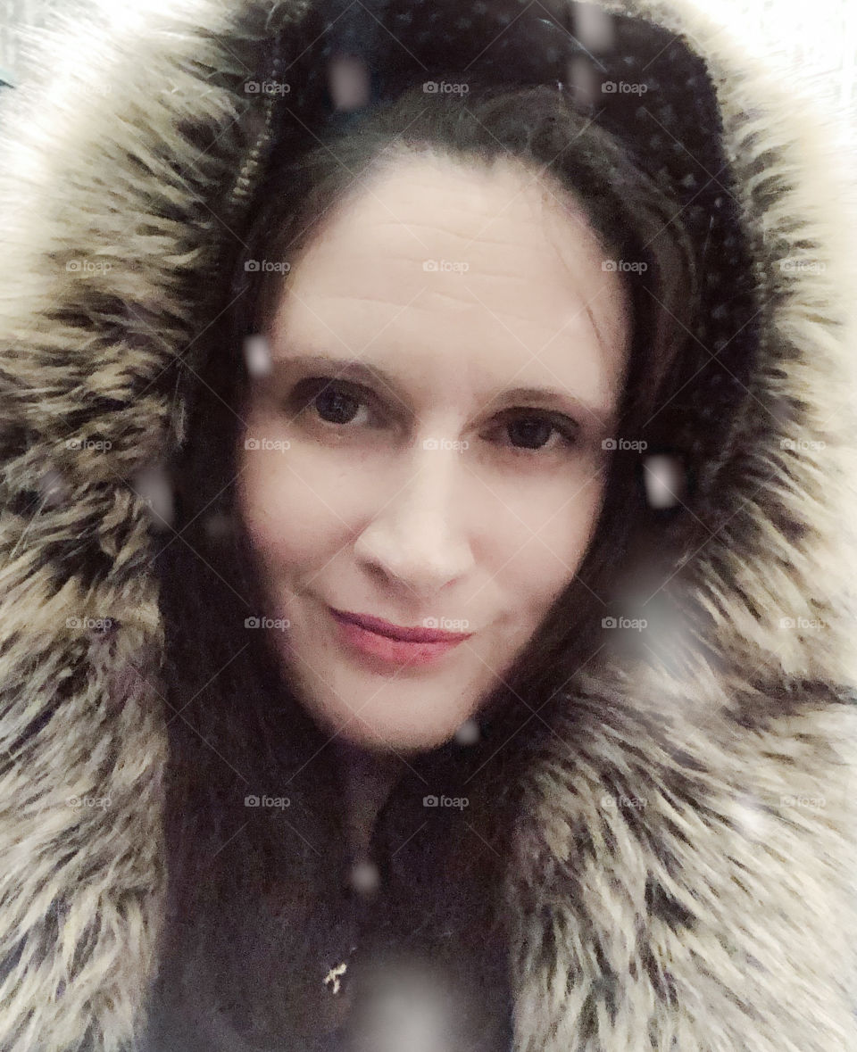 A winter portrait of a woman in a fur lined hood