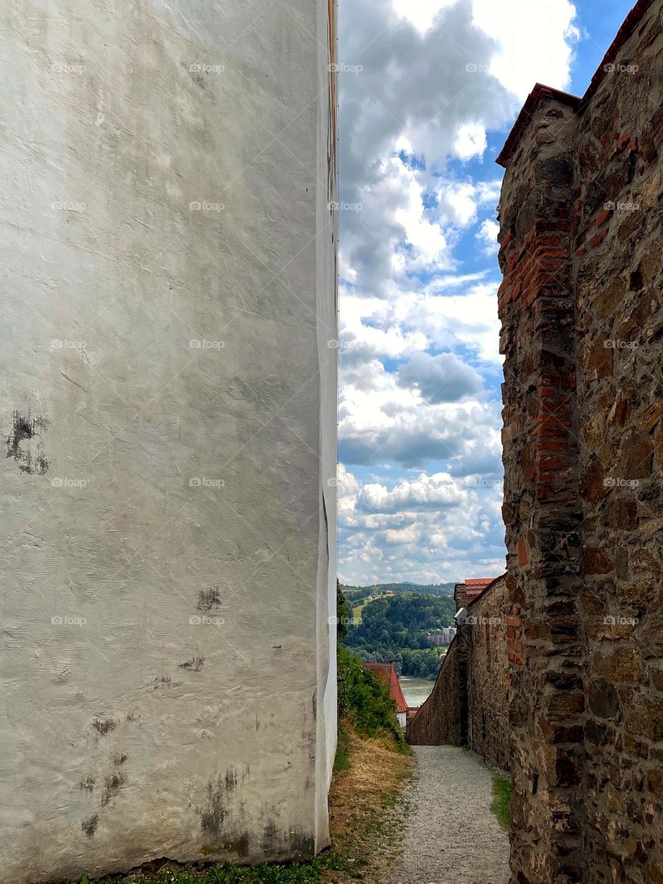 A footpath between an old city wall and the wall of a church