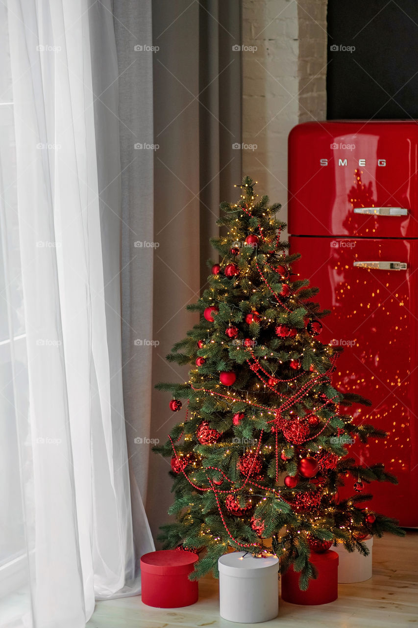 Festive winter cozy kitchen interior with garlands, decorations and gifts.  Christmas dinner at the decorated table.