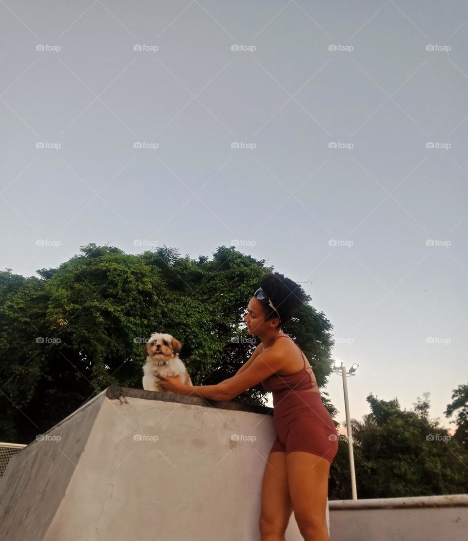 A girl with her dog at a skate park