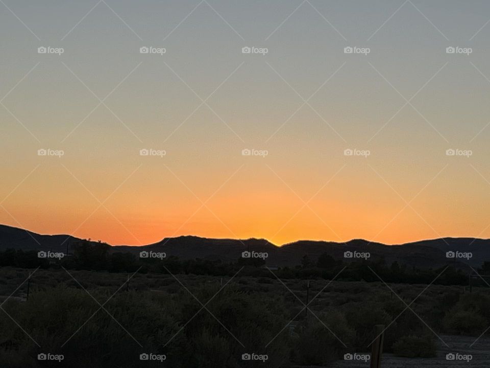 A bright orange sunset with mountains