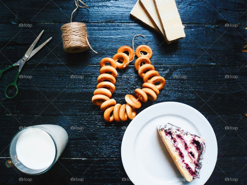 cakes, a cup of milk, bagels and waffles on a black background