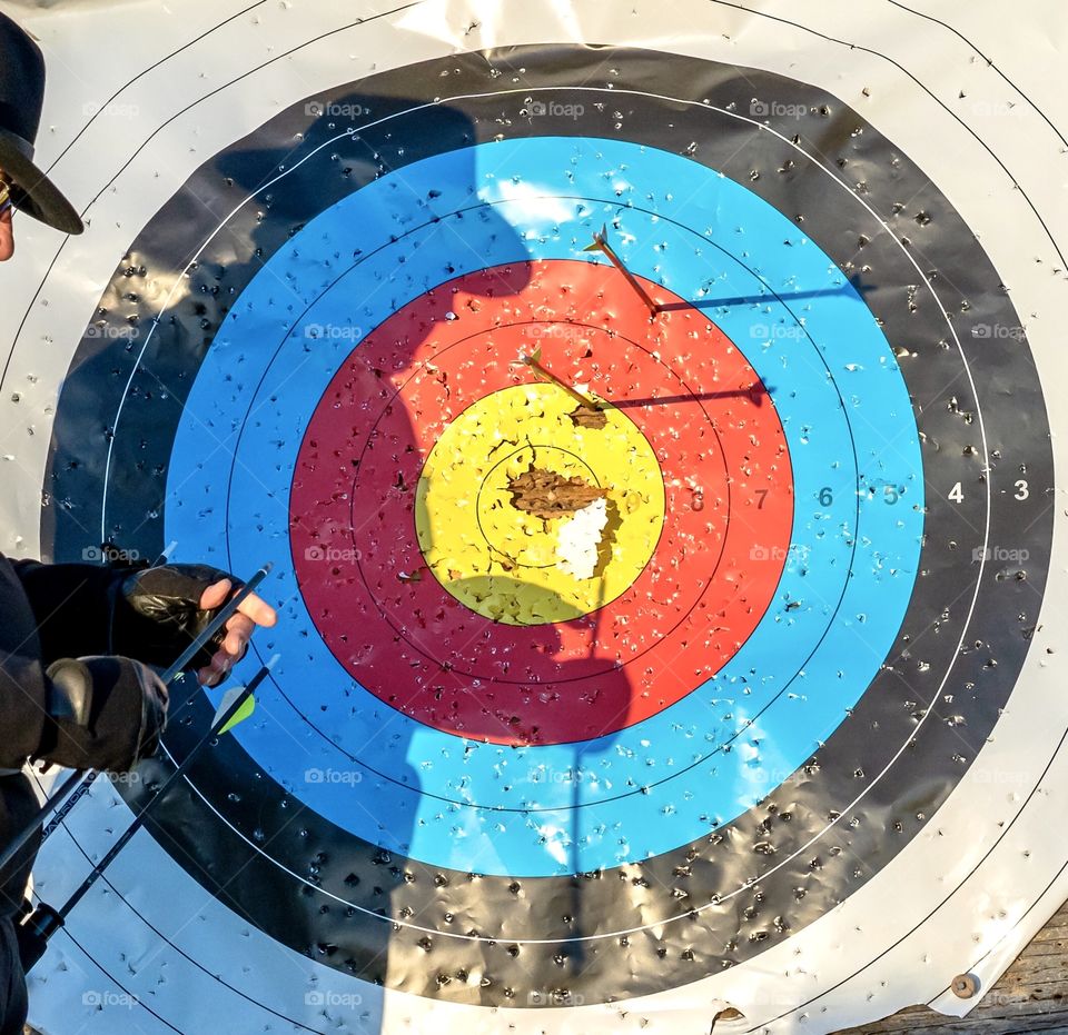 Shadow of an archer on an old archery target 